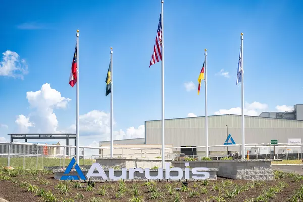 Photo: Aurubis: Building with several flags of different countries in front of a blue sky