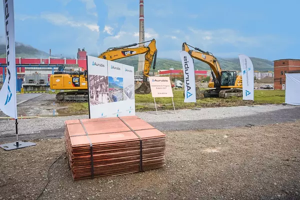 Photo: Aurubis: Several bundled plates, two yellow excavators in the background
