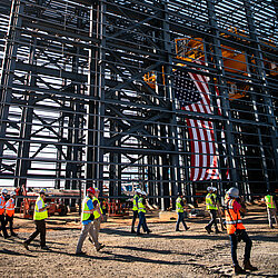 Photo: Aurubis: Scaffolding of a hall that is currently under construction, the USA flag and people can be seen on the construction site