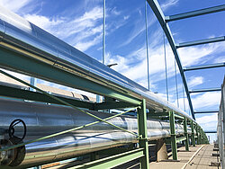 Photo: Aurubis: Several long industrial pipes on a green frame