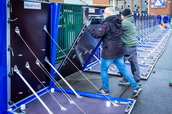 Photo: Aurubis: Two men holding up a panel to protect against flooding
