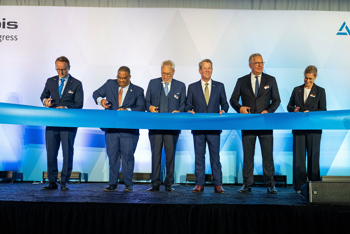 Photo: Aurubis: Several men in suits cut a blue festive ribbon