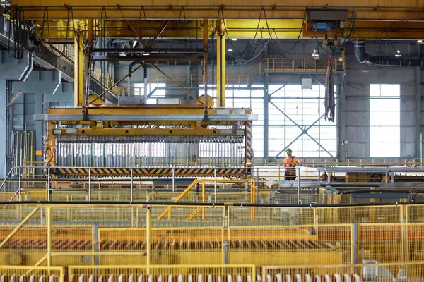 Photo: Aurubis: A large metal machine in a hall attached to the ceiling, yellow scaffolding underneath